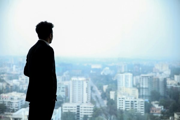 man in a suit looking at city buildings