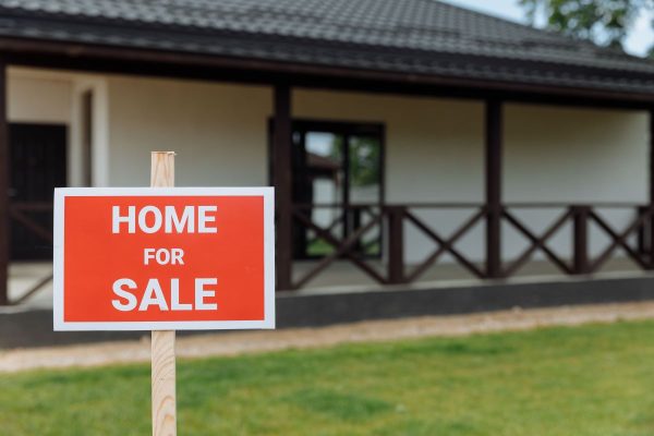 'home for sale' signage in a front yard